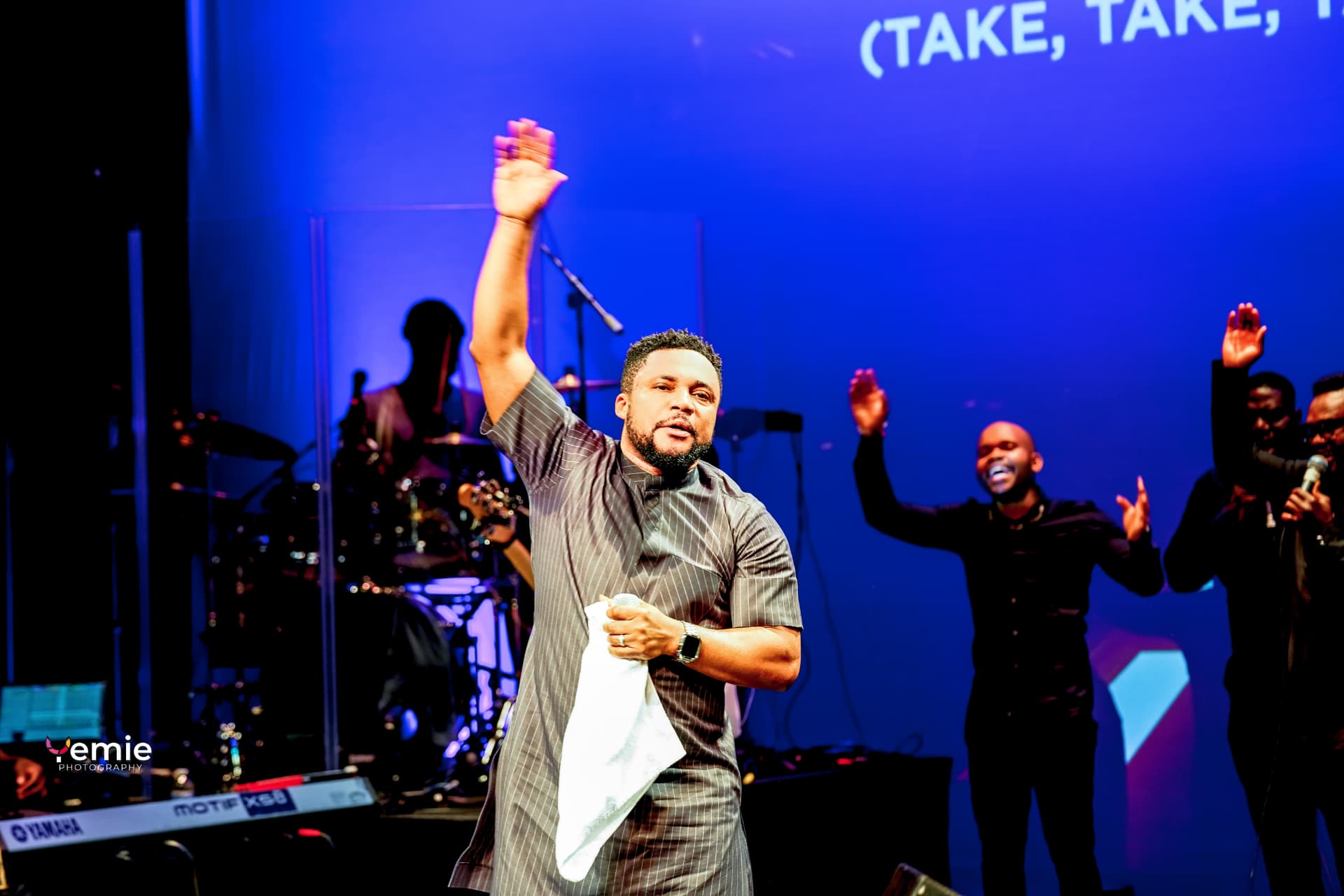 A worship leader raising his hand during a powerful Glorious Praise moment